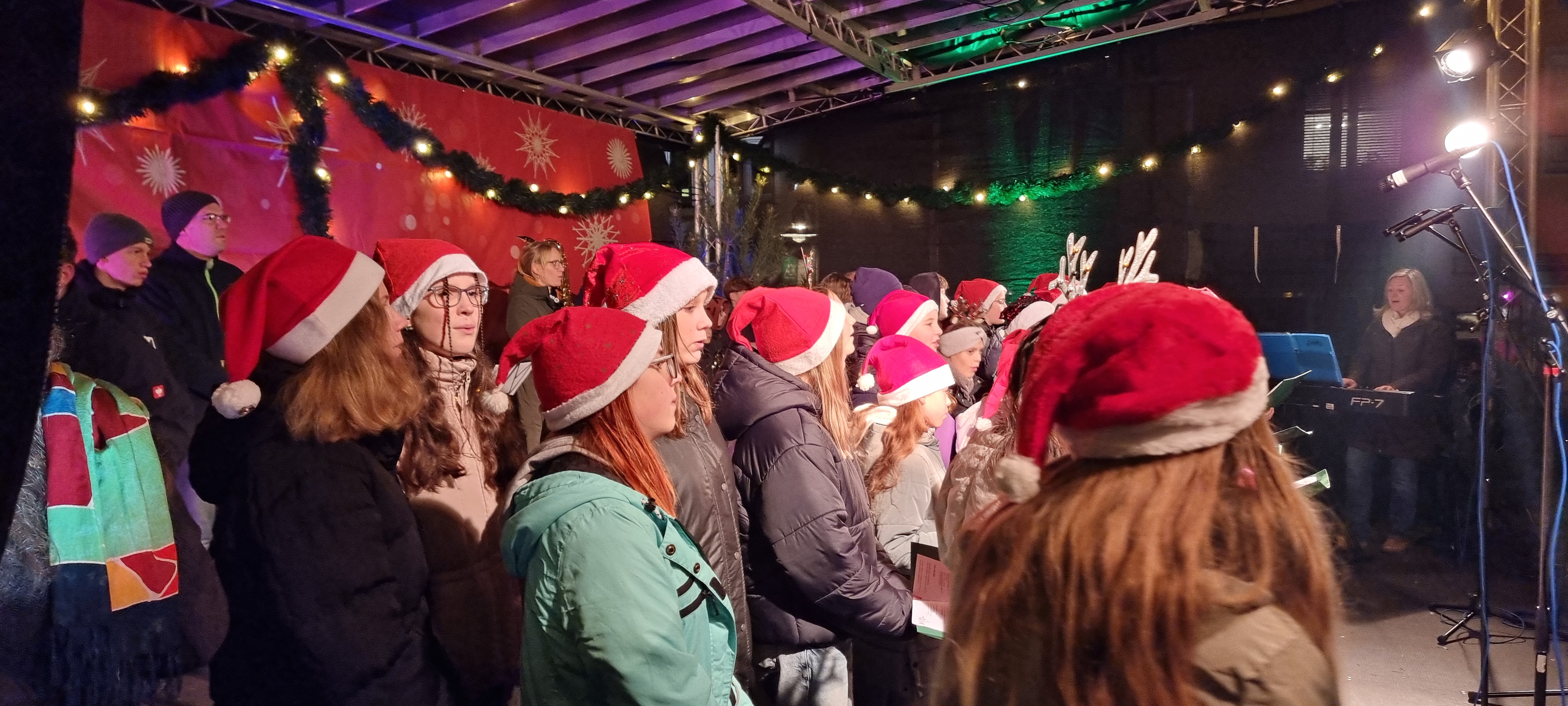 Kinderchor am Weihnachtsmarkt 2025 mit festlicher Bühnenbeleuchtung